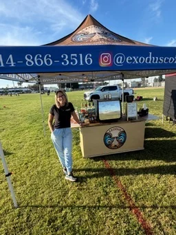 The Exodus Coffee tent and cart set up on a grass field